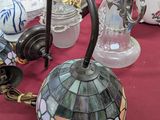 une table sur laquelle se trouve une lampe et de nombreux autres objets