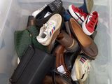 many pairs of shoes and bags in a bin