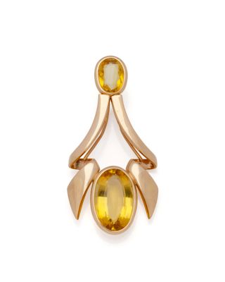 un gros plan d'une bague en or sertie d'une pierre jaune