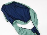 blue and green jacket laying on a white surface