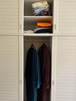 an image of a closet with clothes hanging on it