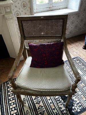 une chaise sur laquelle est posé un coussin, dans une pièce