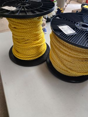 deux bobines de corde jaune posées sur une table dans une pièce