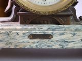 a clock sitting on top of a marble table