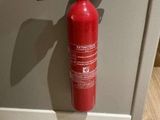 un extincteur rouge fixé au mur