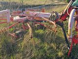 un tracteur qui se trouve dans l'herbe, avec une charrue attelée