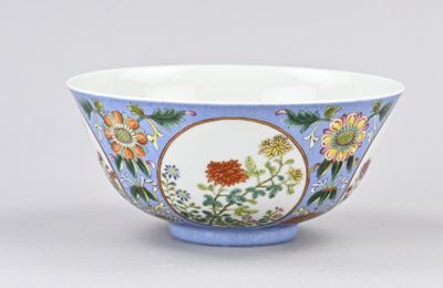 un bol bleu et blanc orné de fleurs et de feuilles
