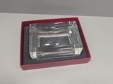 a glass ashtray in a red box on a white table