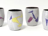 quatre vases ornés de motifs différents, posés sur un fond blanc