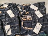 several pairs of jeans with price tags on them sitting on a table