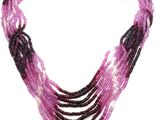 un gros plan sur un collier à plusieurs rangs muni d'un fermoir en or