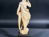 an antique carved ivory figurine of a man holding a trumpet