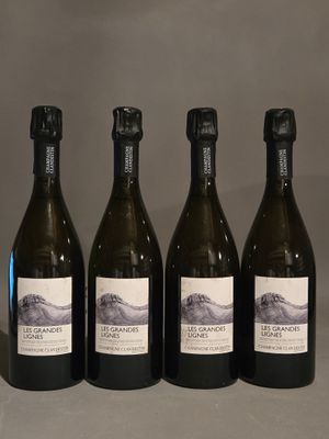 quatre bouteilles de vin sont alignées sur une table