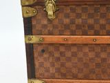 a brown and black suitcase sitting on a white surface