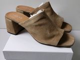 an image of a pair of brown sued mulers on a white box