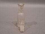 a small glass bottle with a handle sitting on a table