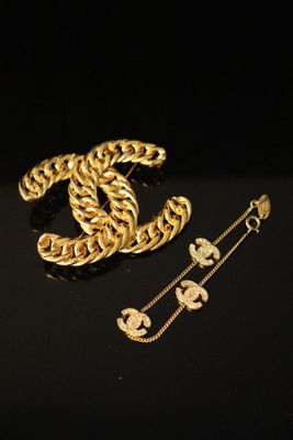 a close up of a gold chain bracelet and a pair of earrings