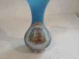 a blue vase with a gold rim on a white surface