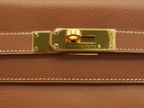 a brown hermeson bag with a gold clasp