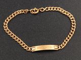 gros plan d'un bracelet en or sur une surface noire