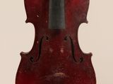 un vieux violon auquel est accroché un archet en bois sur le dos