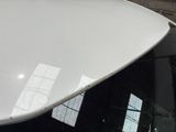 a white surfboard sitting on top of a white car