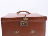 a brown suitcase sitting on a white surface