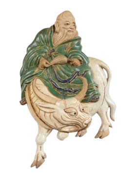 une figurine représentant un homme assis sur une vache