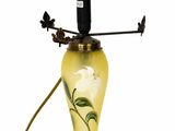 une image représentant une lampe jaune sur laquelle est posé un oiseau