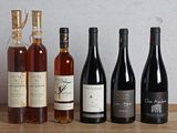plusieurs bouteilles de vin sont alignées sur une table en bois