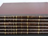 six old books stacked on top of each other on a table