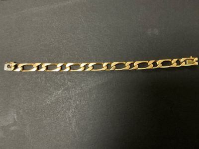 un bracelet en or sur une surface noire