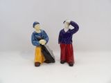 deux figurines d'un homme et d'une femme debout l'un à côté de l'autre