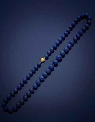 a close up of a blue beaded necklace with a gold clasp
