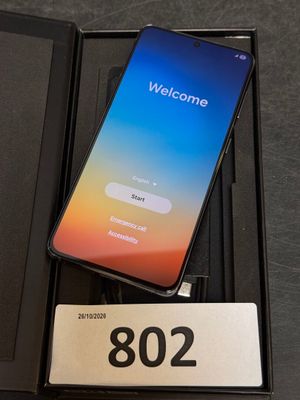 an open box with a phone sitting on top of it on top of a table