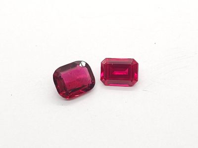 une paire de grenats rouges sur une surface blanche, sur fond blanc