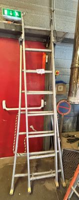une échelle appuyée contre un mur rouge dans un garage