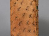 an old book sitting on top of a table next to a gray wall