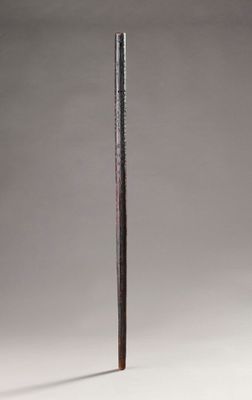 an old wooden stick with a long handle sitting on top of a white surface