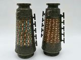 two vases sitting side by side on a white surface