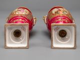 pair of red and gold vases with gold decorations on them