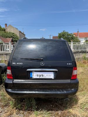 a car that is parked in the grass near a fence