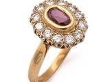 a close up of a gold ring with a ruby and diamond center