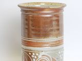 a brown and white vase sitting on a white surface