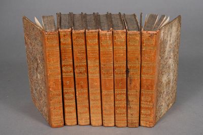 several old books stacked on top of each other on a table
