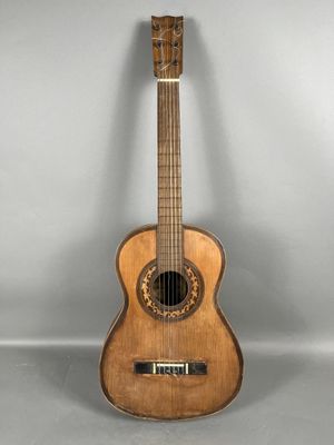 a wooden guitar sitting on top of a gray surface