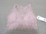a close up of a bra top on a bed with a price tag
