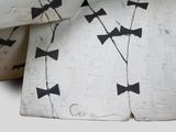 a close up of a piece of paper with black bow ties on it