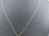 a gold necklace with a white stone pendant on a mannequin