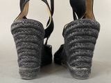 pair of women ' s black wedged sandals on a gray surface